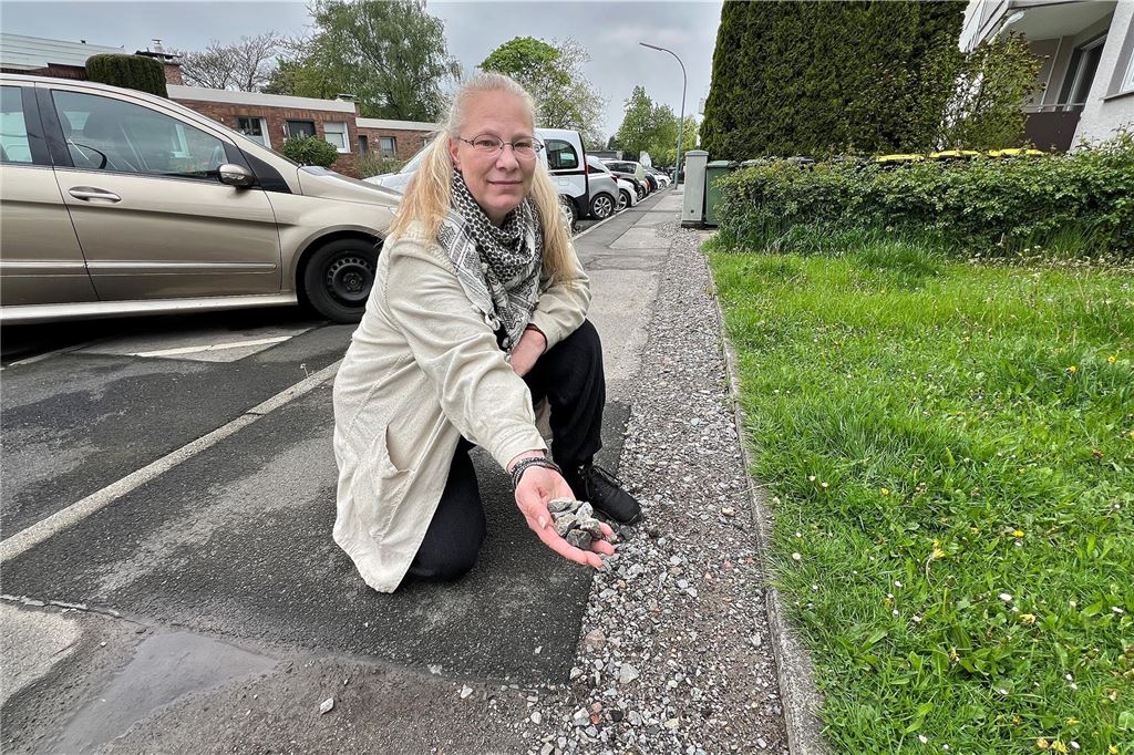 Anwohnerin mahnt: Wege werden durch Glasfaserausbau zu Stolperfallen Angelika Hartjenstein zeigt die lose Schicht aus Steinen, mit der der Gehweg provisorisch geschlossen wurde.