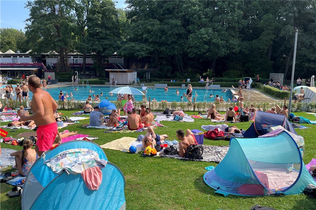 Nach dem Maitanz ist vor Malermarkt, Trödel und Streetfood Freibadbesucher auf der Liegewiese im Bad "Schöne Flöte" in Holzwickede.