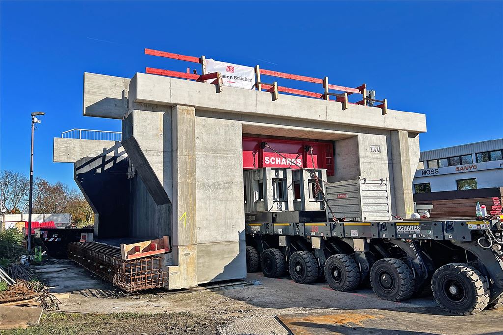 Huckepack mit 450 Tonnen: Die Bahnbrücke an der Mühlenstraße sitzt Abfahrt: Mit einem individuell an diese Brücke angepassten Tragegestell stemmt der Tausendfüßler seine Last in die Höhe, um sie dann vom Fleck zu bringen. Beim Lenken schwenken alle 48 Räder des Fahrzeuges in die entsprechende Richtung.