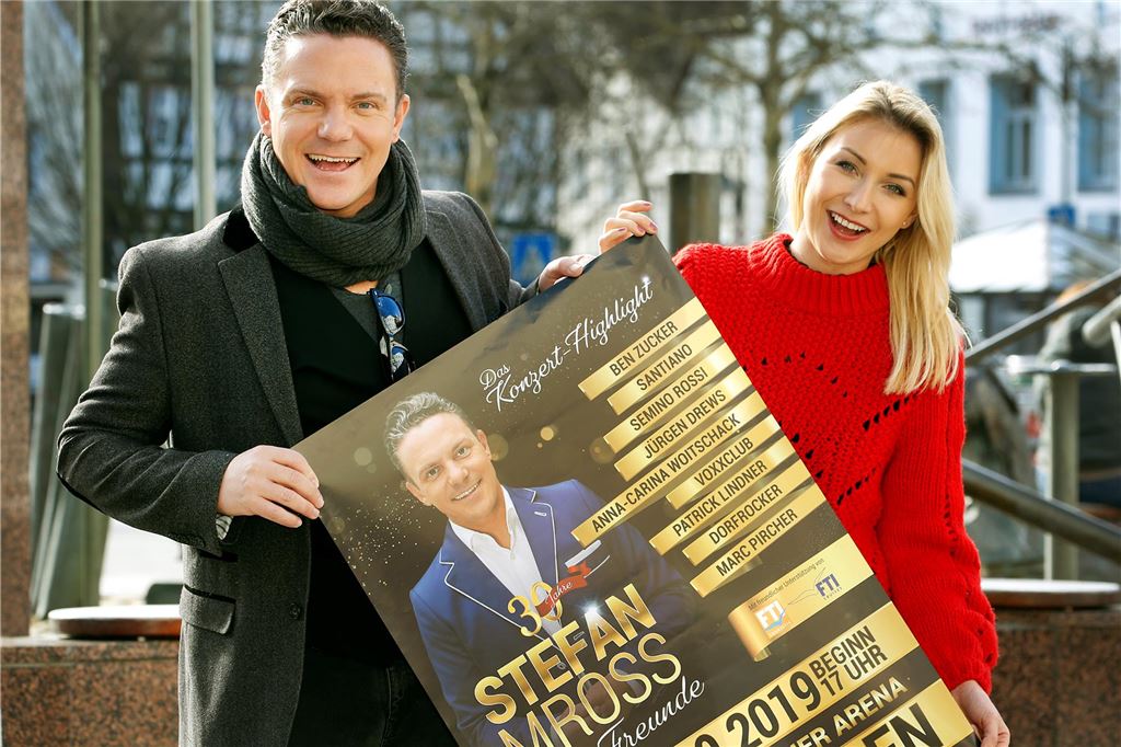 Anna-Carina Woitschack geht ins Dschungelcamp: Ihre Spuren im Kreis Unna Die Volksmusiker Stefan Mross und Anna-Carina Woitschak stehen mit einem Plakat zum 30-jährigen Bühnenjubiläum von Mross auf dem Alten Markt in Kamen