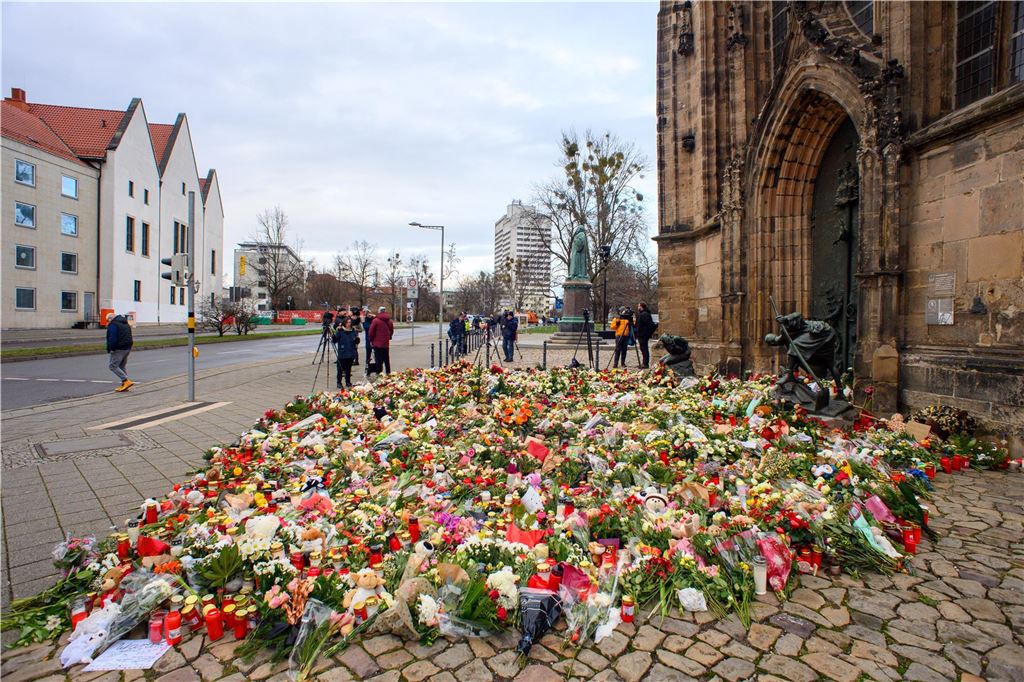 Anschlag auf Magdeburger Weihnachtsmarkt: Fünf Tote, 200 Verletzte - alle Infos im Liveblog Blumen, Kerzen und Kuscheltiere liegen vor dem Portal der Johanniskirche.
