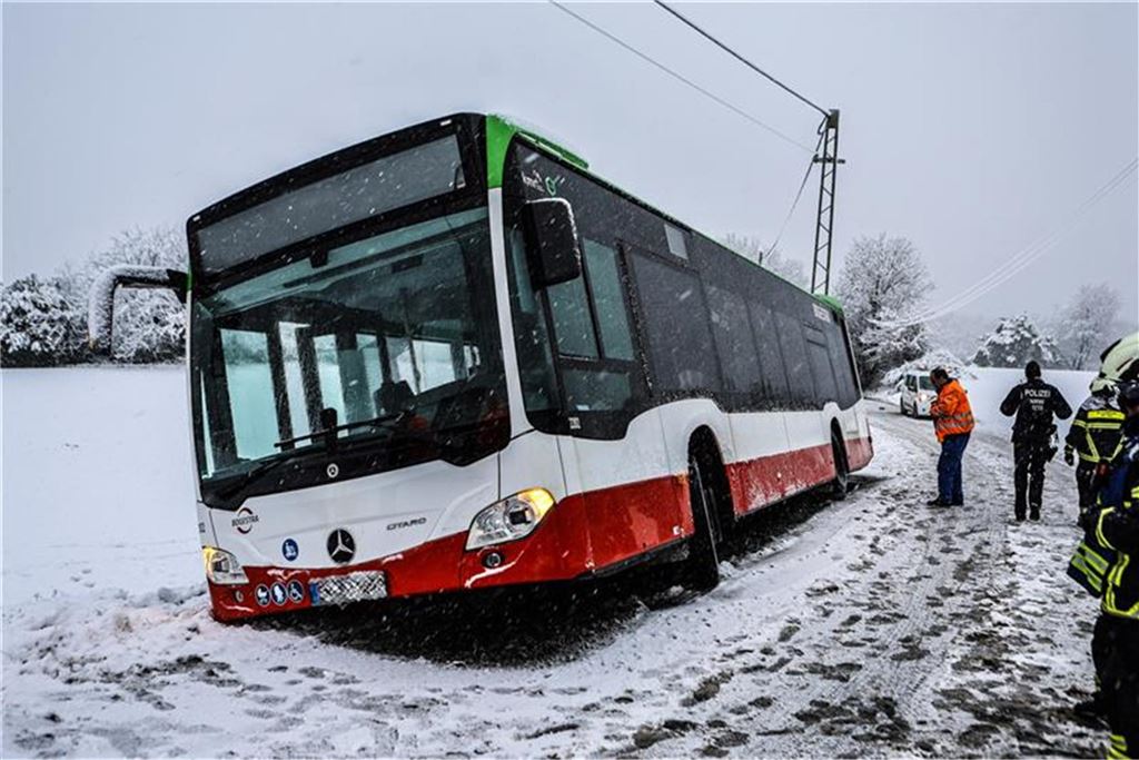Schnee und Eis verursachen viele Unfälle in NRW: Zwei Verletzte bei Kollision in Herdecke – Newsblog Ein Bus steht bei Schnee am Straßenrand und droht eine Böschung hinabzustürzen.