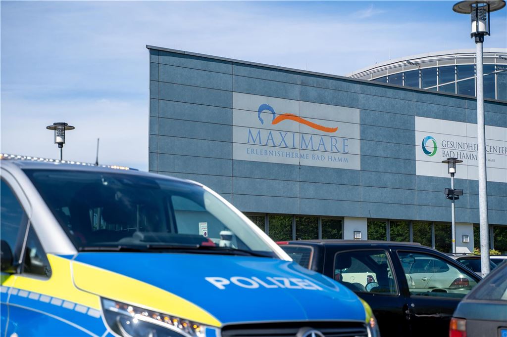 Nach Unglück in Hamm: Wie bereitet sich das Solebad auf den Notfall vor? Ein Polizeiauto steht auf einem Parkplatz vor einem Gebäude. Am Samstag ist ein sechsjähriger Junge im Schwimmbad in Hamm ertrunken.