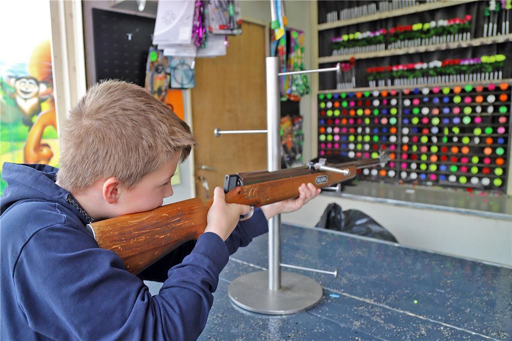 Ein Junge zielt mit einem Luftgewehr auf Sterne.