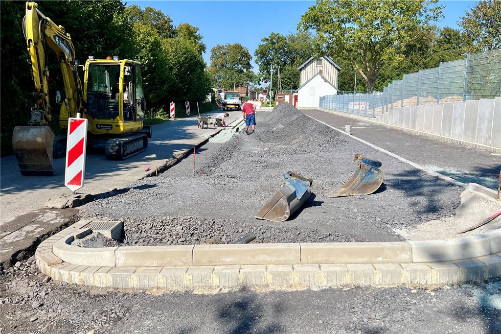Neue Parkplätze für Radfahrer am Bahnhof: Bauarbeiten haben begonnen Am Bahnhof Unna-Lünern ist eine große Baustelle mit Bagger und Bauarbeitern zu sehen. Schotter liegt auf dem Boden, wo neue Parkplätze entstehen sollen.