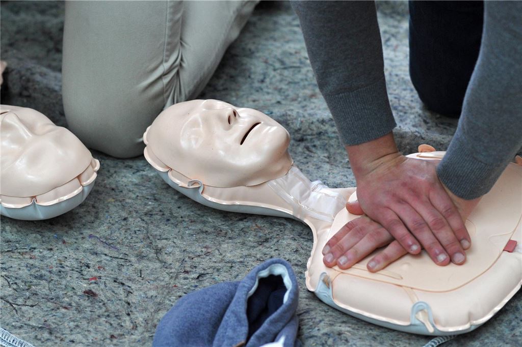 Chefarzt des Krankenhauses wird zum Lebensretter in 12.000 Metern Höhe Eine Person übt Herz-Lungen-Wiederbelebung an einer Reanimationspuppe.