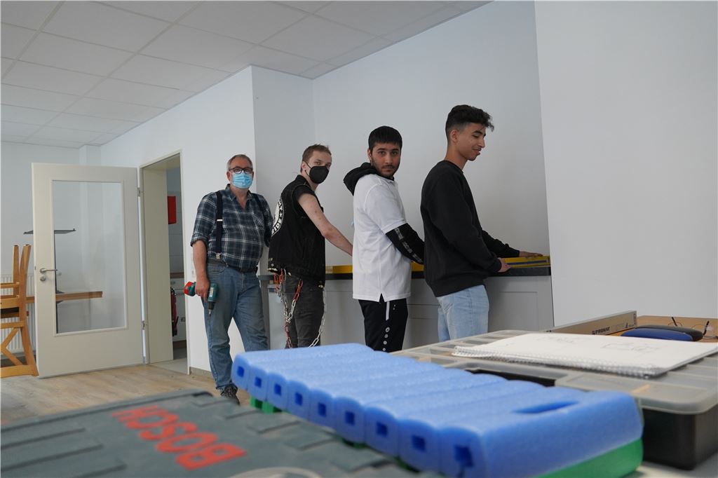 Begegnungscafé in Königsborn ist schon vor seiner Eröffnung wertvoll Anleiter Ludger Busch arbeitet mit den Teilnehmern Daniel Dreßler, Fashid Safi und Laeth Al Abdullah an der Rückwand der Theke für das Begegnungscafé.
