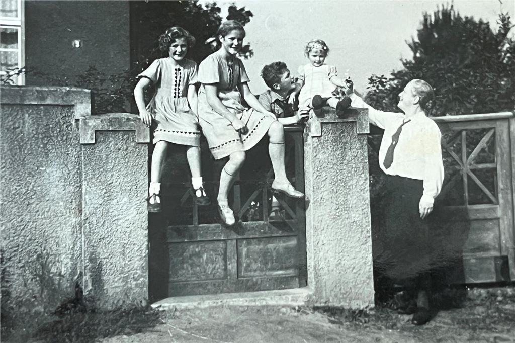 Ein Kriegsfoto und seine Geschichte: „Das ist meine Schwester“ Annemarie ist die große Schwester, die auf der grünen Pforte am Tiggesgraben 3 sitzt. Nicht im Bild ist der rechte Pfeiler des Gartentors. Dieser soll einer der auf dem Kriegsfoto abgebildeten Pfeiler sein.