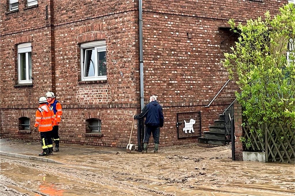 Anwohner müssen ihre Grundstücke von dem Schlamm befreien.