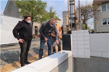 Architekt Christoph Dörrich, Caritas-Vorstand Ralf Plogmann und Bauunternehmer Thomas Kleine-Krabbe (v.l.) bauten die Zeitkapsel in die Mauern des Hauses ein, das an der Zechenstraße 17 gebaut wird.
