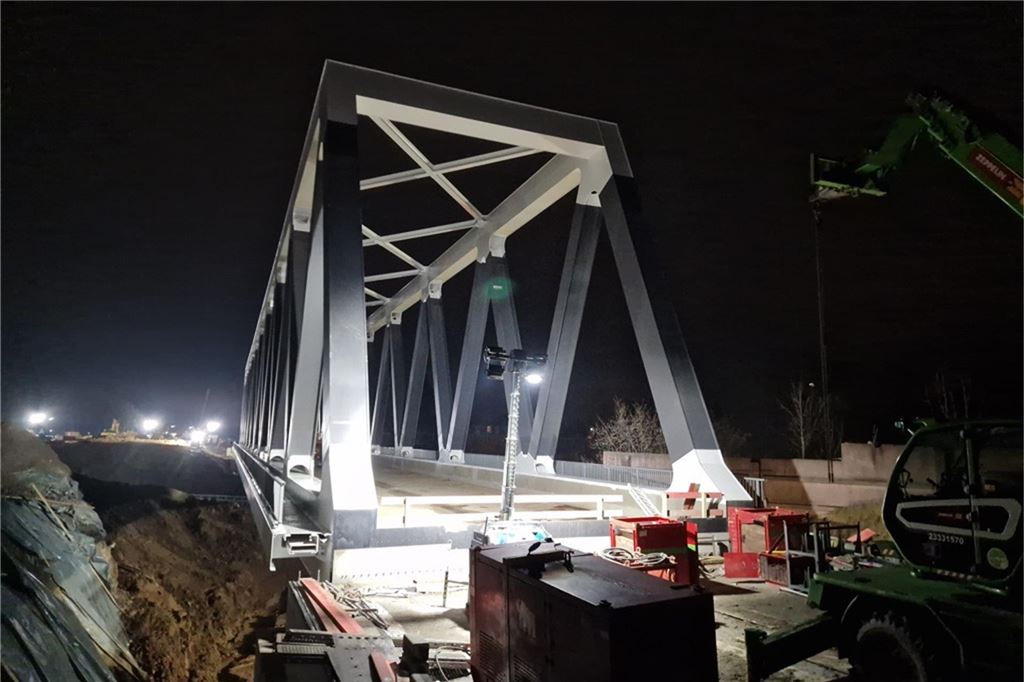 2.000 Tonnen auf Rädern, A1 gesperrt: Liveblog vom spektakulären Brückenbau in Unna Die neue Eisenbahnbrücke der Deutschen Bahn über die A1 bei Unna wird am Sonntagabend, 8. Dezember 2024, von einem Bauscheinwerfer angestrahlt.