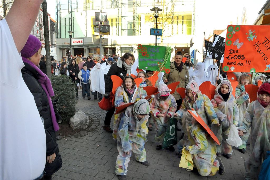 Erinnerungen an den Rosenmontagszug der Schulen Junge Karnevalisten in Kostümen sammeln Kamelle in einer Fußgängerzone.