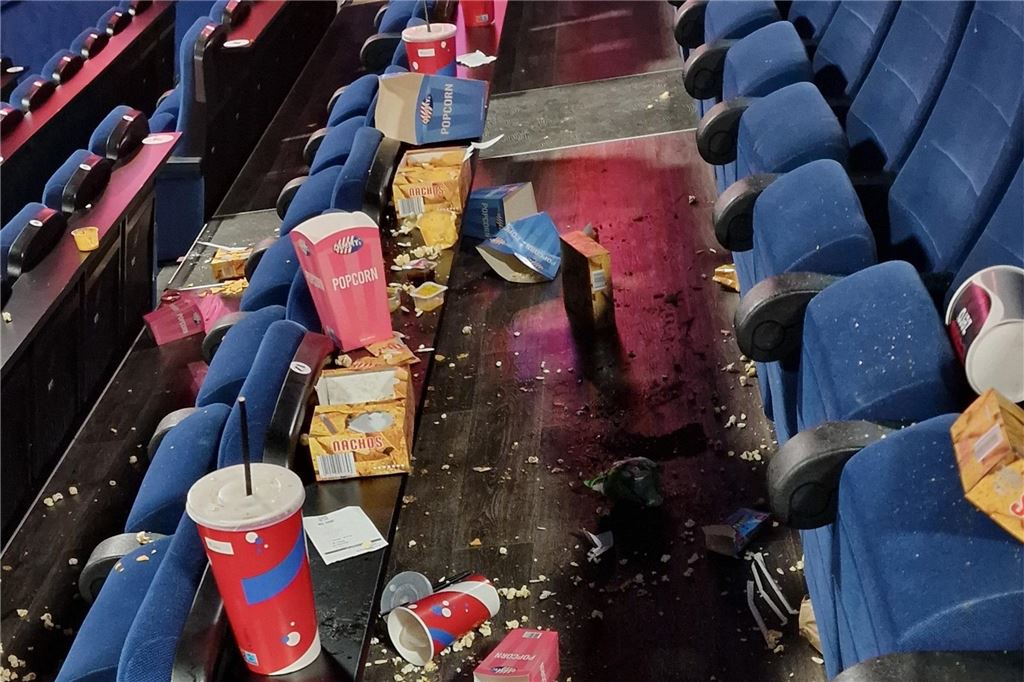 „Einfach nicht mehr hin“: Diskussion um Taschenkontrollen in Unnaer Kino Ein leerer Kinosaal voller Müll: Trinkbecher, Popcorn und Popcorntüten.