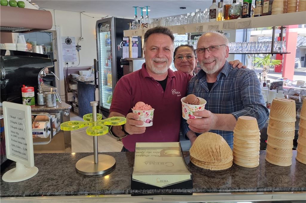 Eispreise gestiegen: Das kostet eine Kugel Eis in der Stadt Drei Menschen stehen hinter einem Tresen im Eiscafé Crema in Unna.