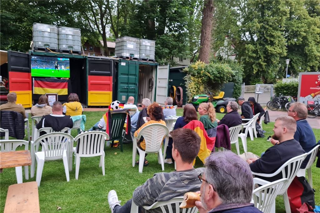 Public Viewing in Gaststätten: Hier sehen Sie das Deutschland-Spiel Fußball-Fans sitzen im Freibad auf Plastikstühlen und gucken ein Länderspiel.