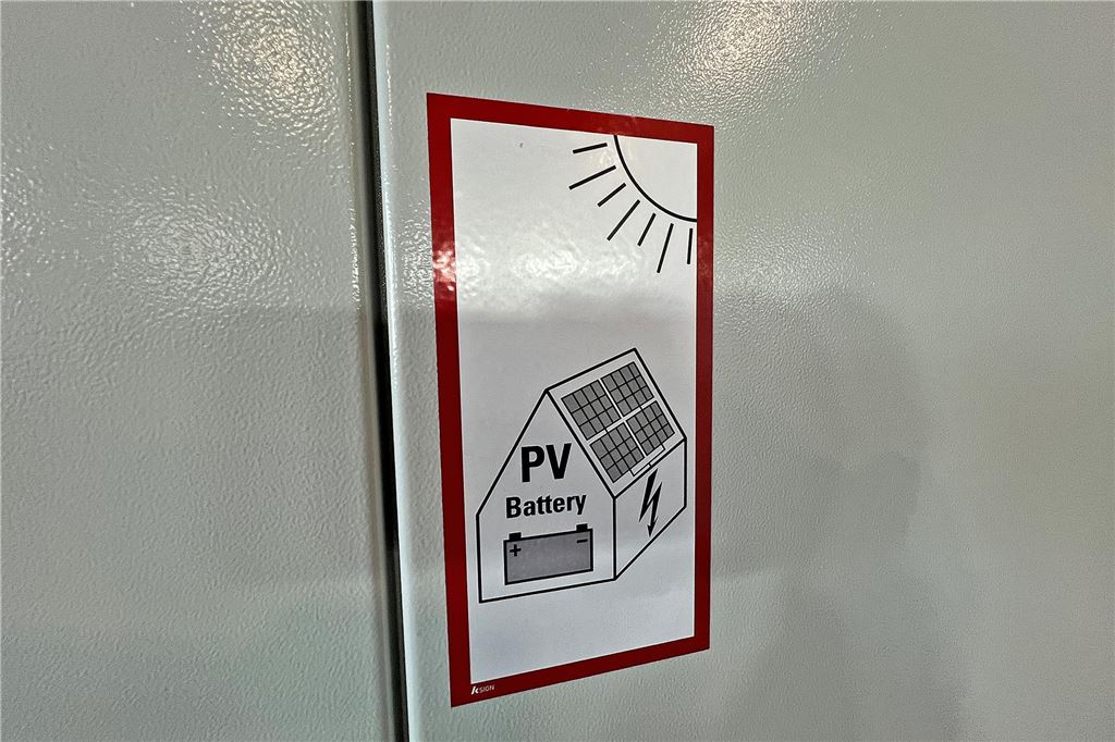 „Es muss Luft zirkulieren können“: PV-Experte gibt Tipps nach Akku-Brand in Ardey Ein Sicherheitsaufkleber am Speicher, der auf die PV-Anlage hinweist.