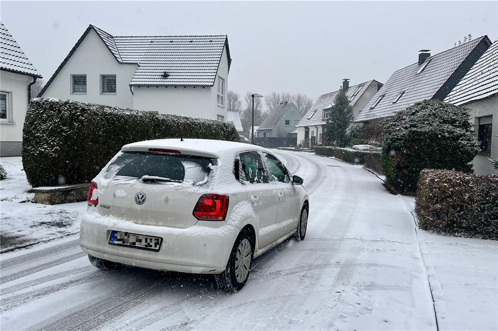 Unfälle durch Schnee und Glätte am Abend im Kreis Unna Ein weißes Auto fährt in Fröndenberg über eine verschneite Straße