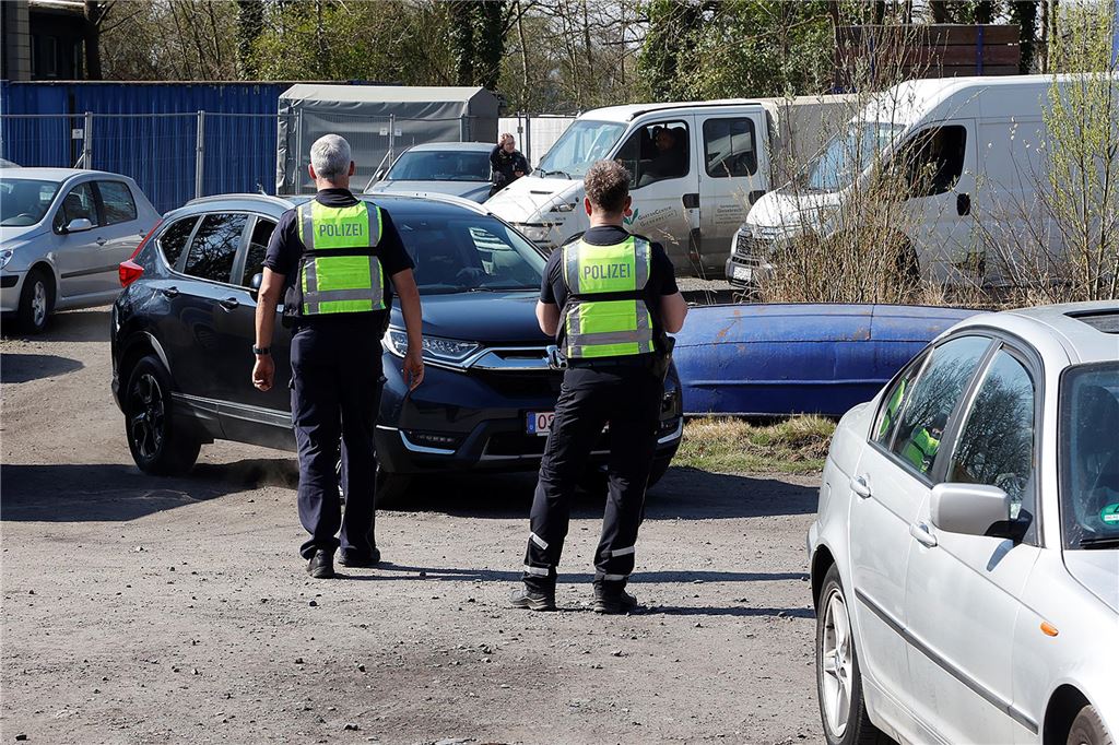 Polizei hat wieder Autofahrer an der Werner Straße kontrolliert Zwei Polizisten mit Warnwesten stehen vor einem Auto, das kontrolliert werden soll.