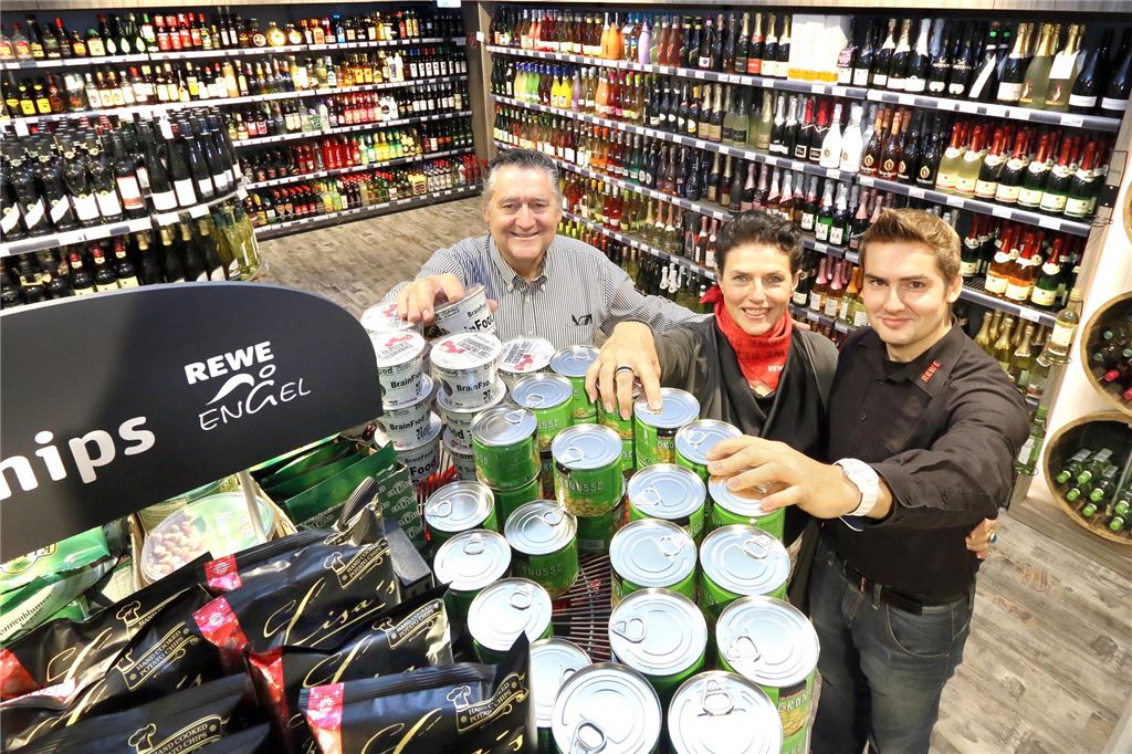 Umbau in Massen: Lotto-Laden kleiner, Möbel Jürgens vor Abschied Helmut, Sylvia und Alexander räumen gemeinsam einen Warenaufsteller mit Knabberkram ein. Ihr Rewe-Markt in Unna-Massen ist ein echter Familienbetrieb.