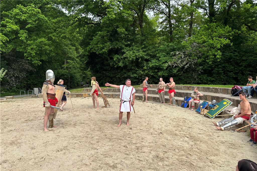 Der Gladiatorenmeister steht vor den Gladiatoren.