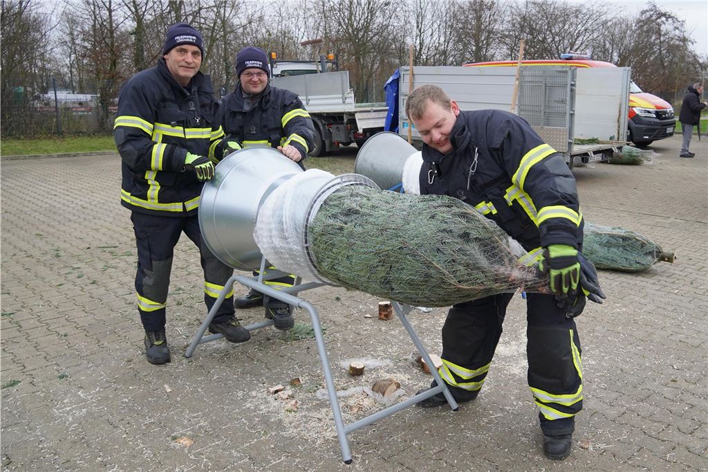 Aushilfsrentier „Sunshine“ unterstützt die Löschgruppe 2 Beim Verpacken der Weihnachtsbäume gingen die Feuerwehrleute der Löschgruppe 2 den Besuchern zur Hand (v.l.): Dieter Lammert, Daniel Schoof und Marcel Auth.