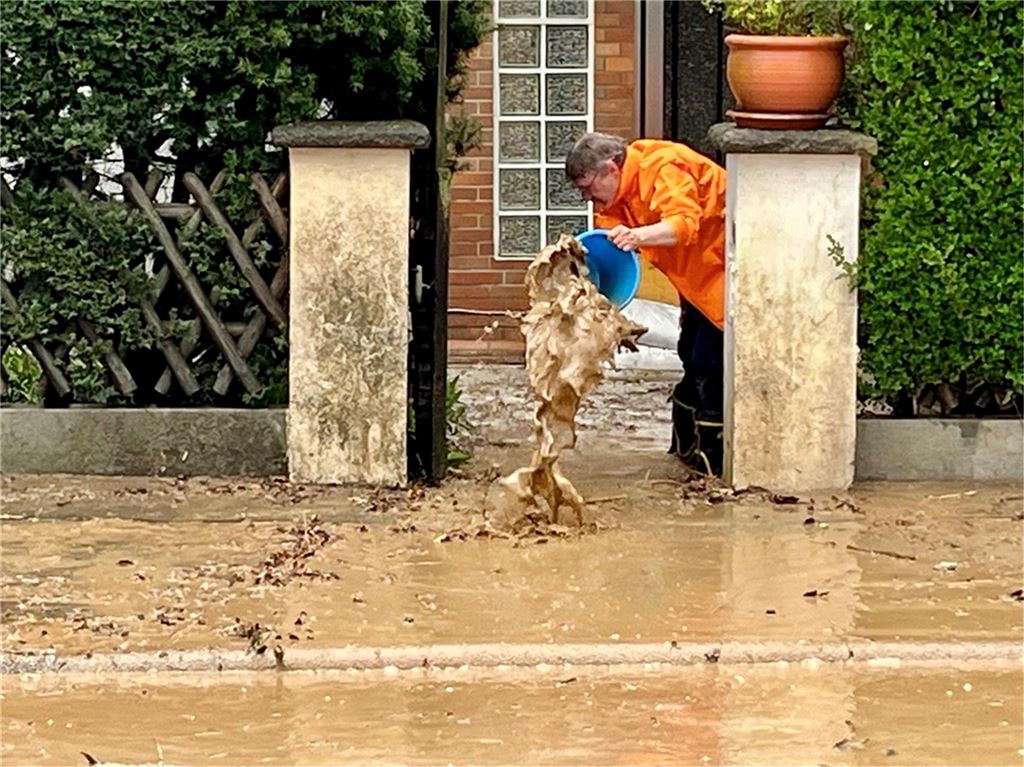 Nach Starkregen: CDU fordert eigene Stelle für Hochwasserschutz Anwohner schüttet Eimer voll mit schmutzigem Wasser auf die Straße