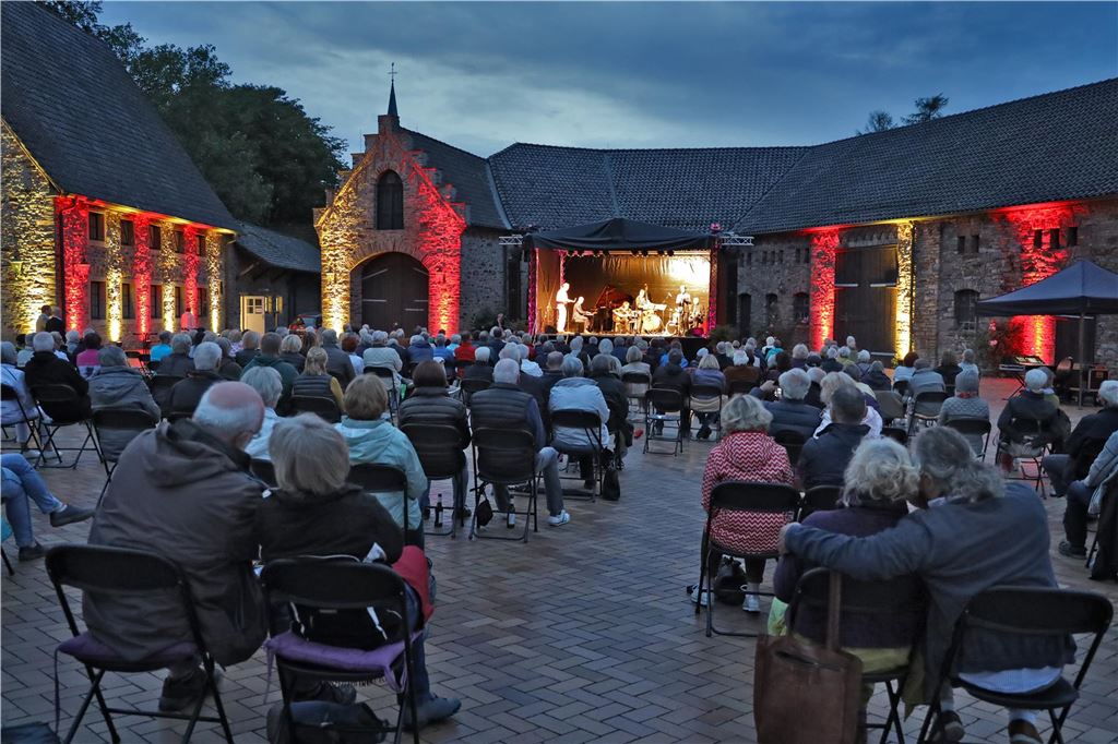 Sommerbühne 2025: Vorverkauf für Musik und Comedy gestartet Besucher des Open-Air-Festivals „Sommerbühne 2025“ auf Haus Opherdicke dürfen sich wieder auf hochkarätige Künstler freuen. Auf diesem Bild sitzen Besucher des Open-Air-Festivals auf Stühlen und schauen gemeinsam auf die Bühne. (Archiv)
