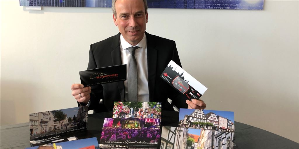 Händler appellieren an Bürger: „Kümmert euch um eure Innenstadt!“ Peter Zahmel präsentiert die sechs verschiedenen Motive des neuen Gutscheins, den der City-Werberings Unna herausbringt. Mit der Kampagne soll der lokale Einzelhandel in der Corona-Krise gestärkt werden.