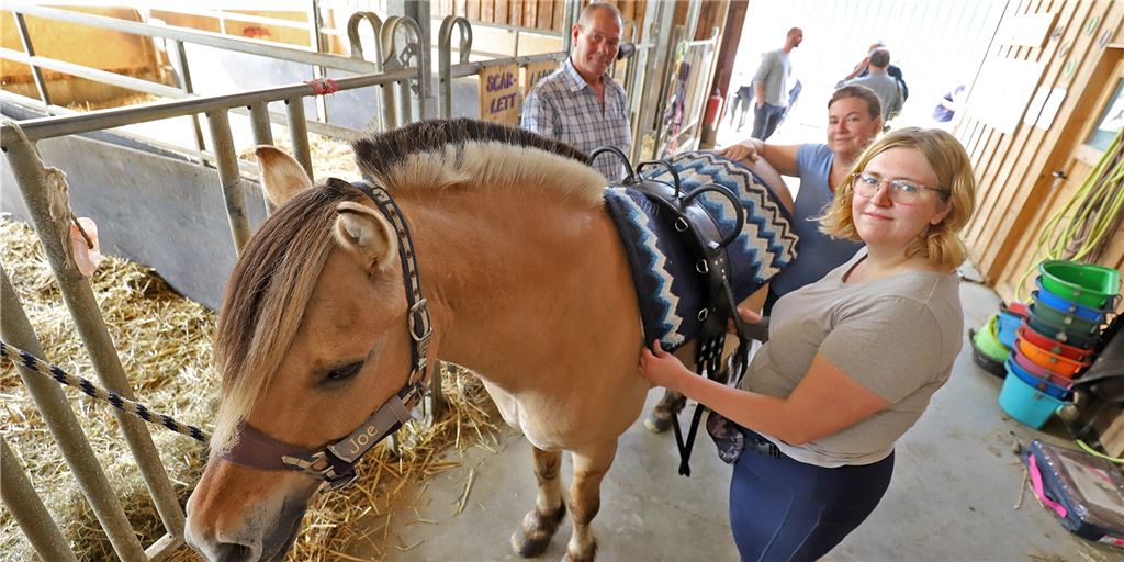 Arbeiten auf dem Ponyhof: Alltag für eine Autistin in Fröndenberg Durch das Integrationsprojekt „NeuEinstellung“ ist es Lara Bergmann (rechts) gelungen, auf dem Hof „Ratz Rabatz“ in Ostbüren eine Arbeitsstelle zu finden. Gerade sattelt sie ihr Lieblingspony Joe. Ermöglicht haben ihr das ihr früher Betreuer Uwe Lopens vom Projekt „NeuEinstellung“ und ihre Chefin Jeannette Lategahn.