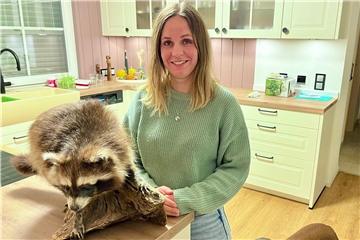 Jägerin Yvonne Schulz-Garbe mit Hund und Waschbär-Präparat in der Küche.