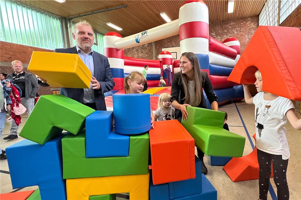 „Die Turnhalle ist unser Schmuckstück“: Kita Glückspilze feiert Eröffnung Bürgermeister Dirk Wigant und Kitaleiterin Mandy Wagner mit Kindern und bunten Würfeln in der Turnhalle.