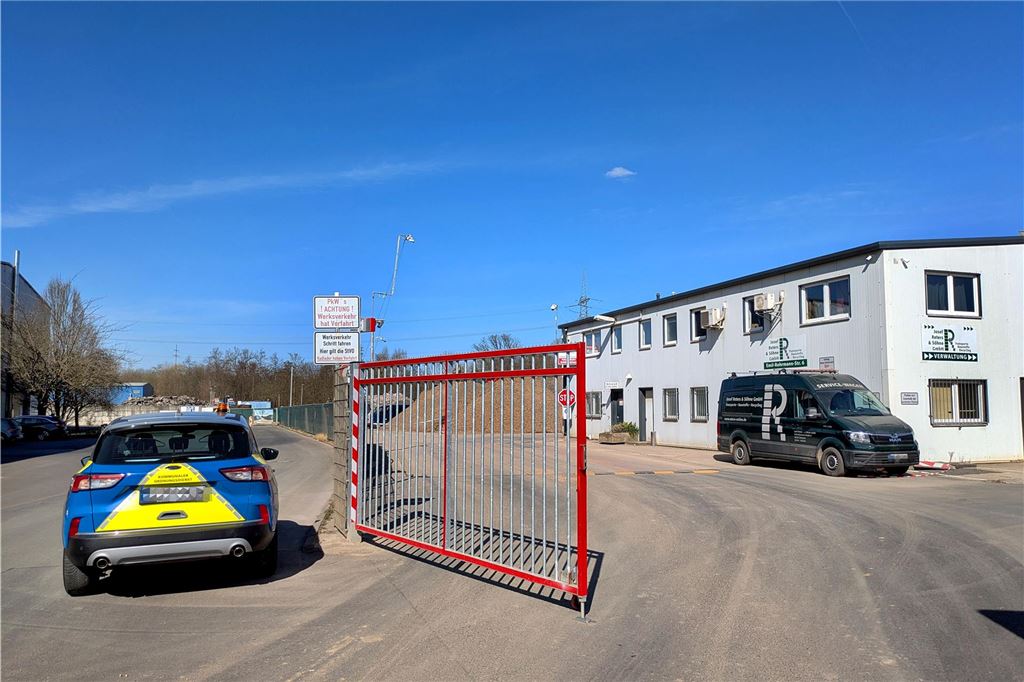 Evakuierung nach Bombenfund: Blindgänger wird kontrolliert gesprengt Das Auto eines Kommunalen Ordnungsdienstes steht neben dem Eingangstor zu einem Betrieb.