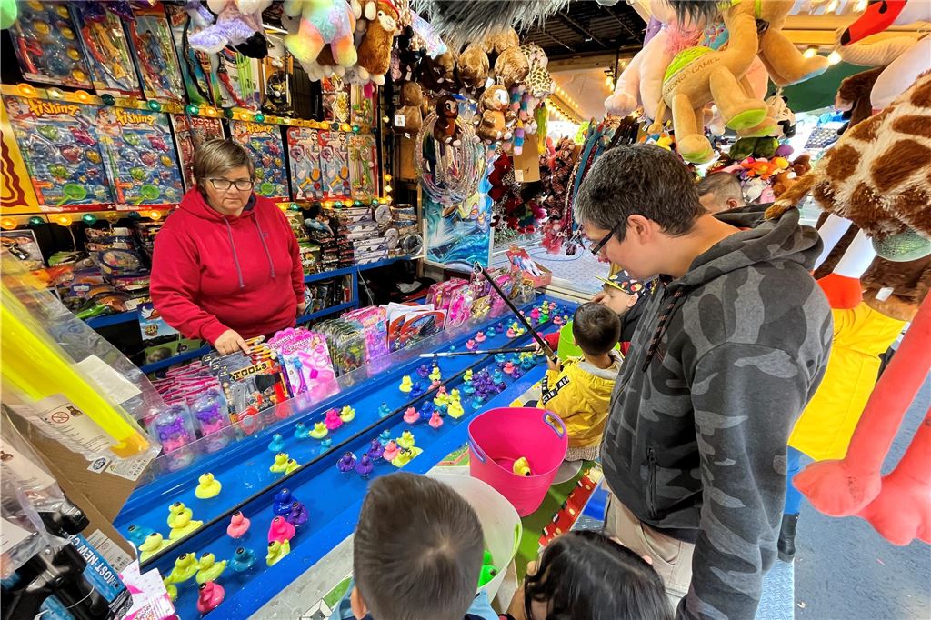 Maikirmes 2025: Alle Infos zum Ablauf, den Ständen und Parkplätzen Eine Familie steht an dem Entenangeln-Stand auf der Maikirmes in Werne.