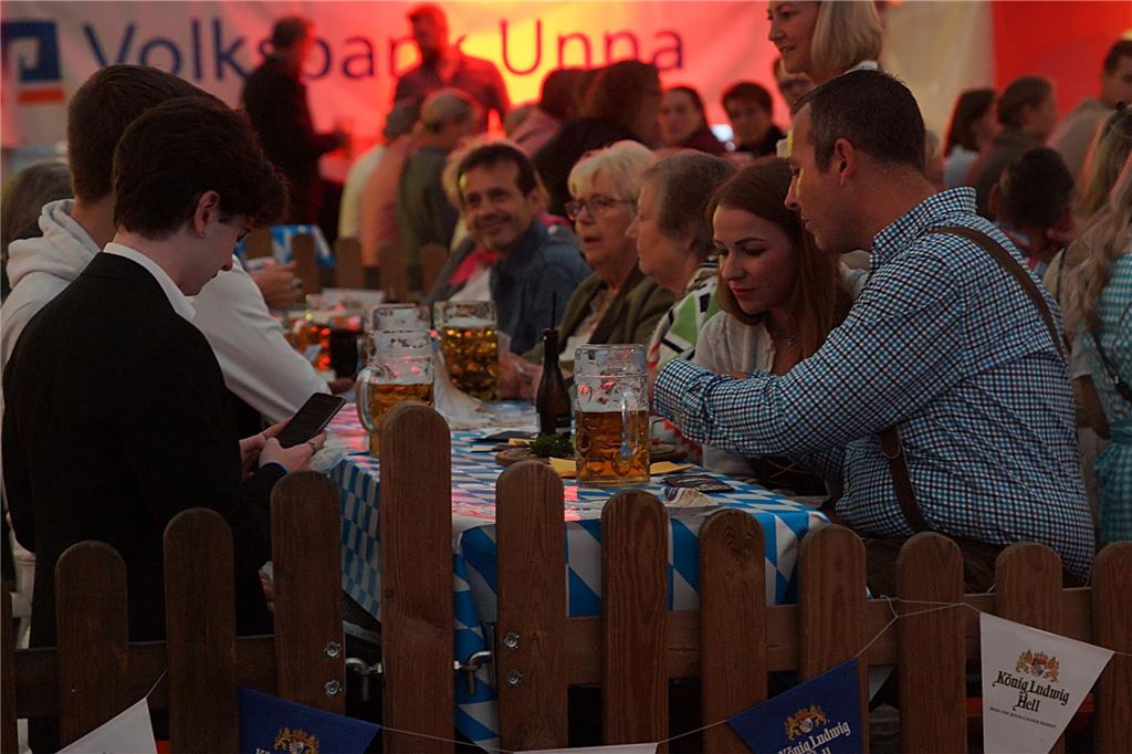 Oktoberfest oder interkulturelles Programm: Das Wochenende im Kreis Eine Gruppe Menschen sitzt beim Oktoberfest an der Stadthalle in Unna an einem Biertisch.