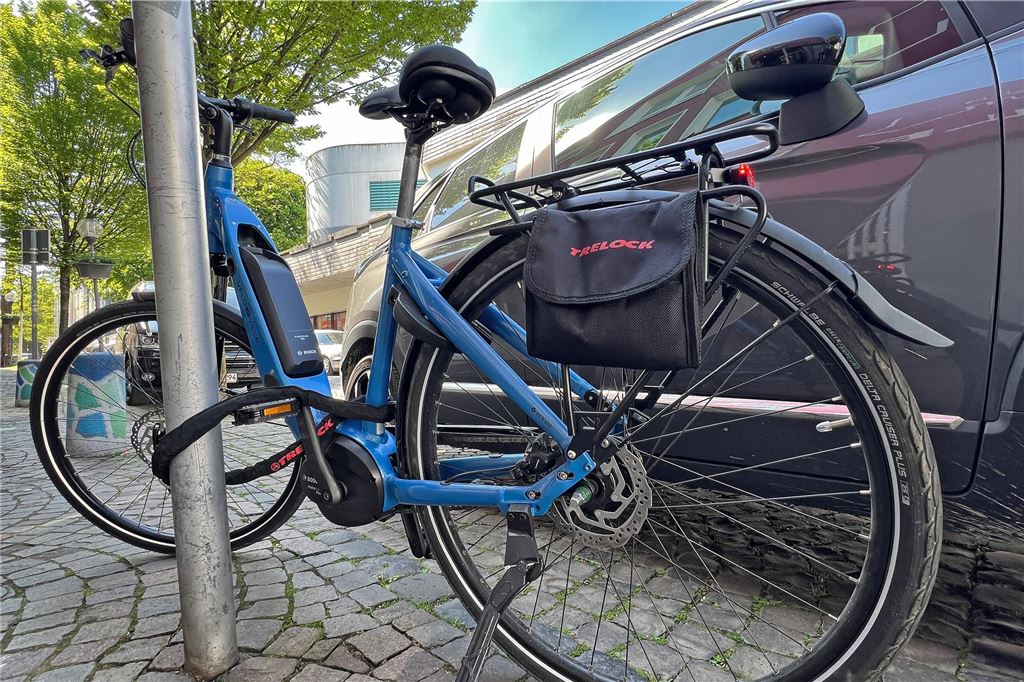 Stadt Unna plant Kampagne gegen Fahrrad-Falschparker Ein blaues Fahrrad ist an einem Schilderpfosten angekettet. Direkt daneben parkt ein Auto