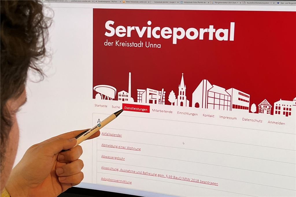 Rathaus wird digital und spricht freundliches Klammer-Verbot aus Ein Mann zeigt mit einem Stift auf die Serviceportal-Internetseite der Stadt Unna
