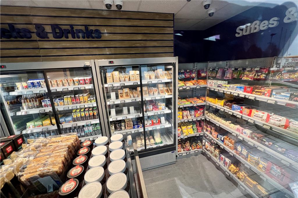 Probleme bei Rewe-Markt: Einkaufen nur mit Kreditkarte oder digital Ein Blick auf das Sortiment von Rewe-Ready in Kamen. Totale von Außen ins Geschäft, es sind mehrere gut befüllte Regale zu sehen.