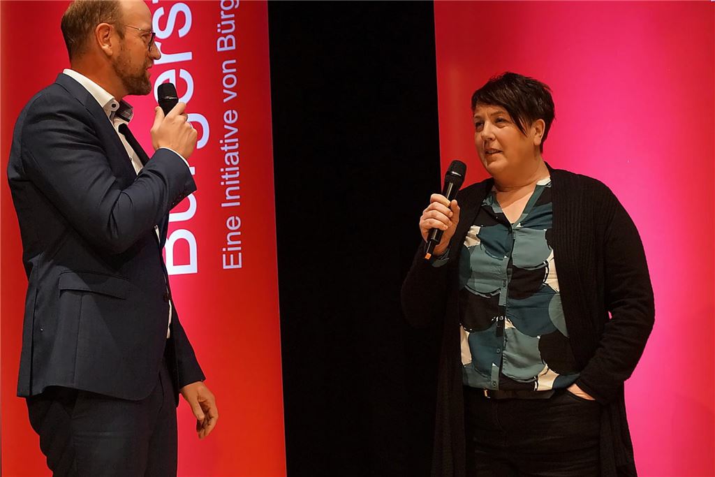 Mirco Rienhoff (Sparkass) und eine Vertreterin des SV Bausenhagen auf der Bühne der Stadthalle Unna.