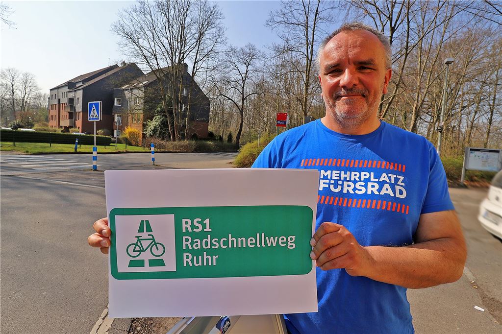 Vorzugstrasse für Radschnellweg Ruhr soll 2025 vorgestellt werden Der 1. Vorsitzende des ADFC-Kreisverbandes Unna Dr. Andreas Abel hält ein Werbeschild für den Radschnellweg Ruhr in die Höhe.