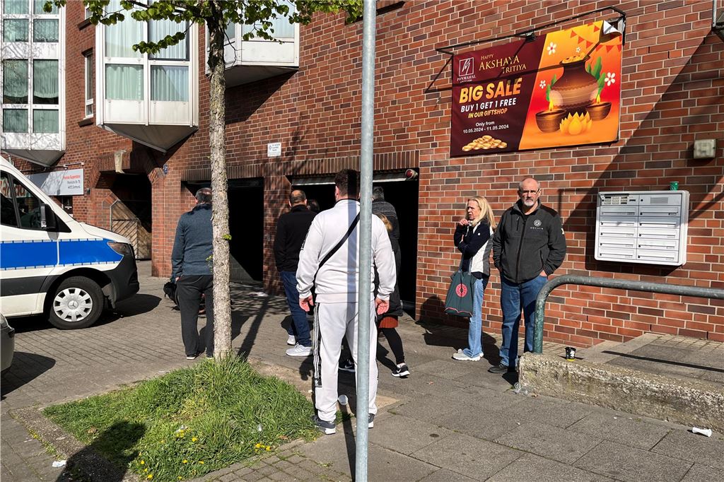 Menschen stehen vor einer Tiefgarage.