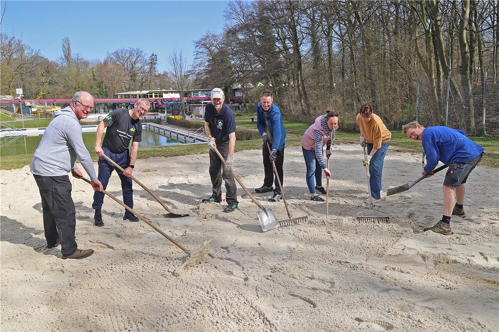 Mitglieder des Freibad-Fördervereins Schöne Flöte richten den Beachvolleyballplatz für die Saison her.