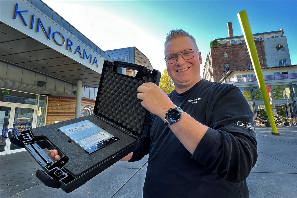 Geheimkoffer erreicht Unnas Kino: Sven Hilbk (38) gibt spannenden Einblick Sven Hilbk steht vor dem Kinorama und hält den Geheimkoffer mit der Festplatte.