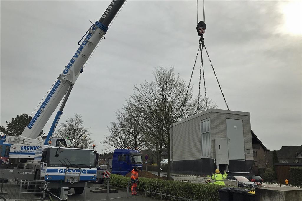 Fröndenberg erhält Glasfaser-Knotenpunkt von Westconnect Totale eines Krans, an dem ein garagenartiges Häuschen hängt.