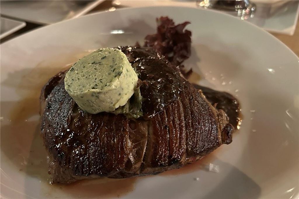 Perfektes Steak und ein Veggie-Experiment im Steakhouse „Le Bon Filet“ Ein Filetsteak auf weißem Teller. Obendrauf liegt ein Stück Kräuterbutter im „Le Bon Filet Steakhouse“ in Dortmund