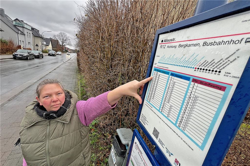 Wieder lässt VKU Schüler stehen: Mutter beklagt Probleme mit Schulbus Susanne Padberg zeigt auf ein Schild mit dem Busfahrplan, das an einer Haltestelle hängt.