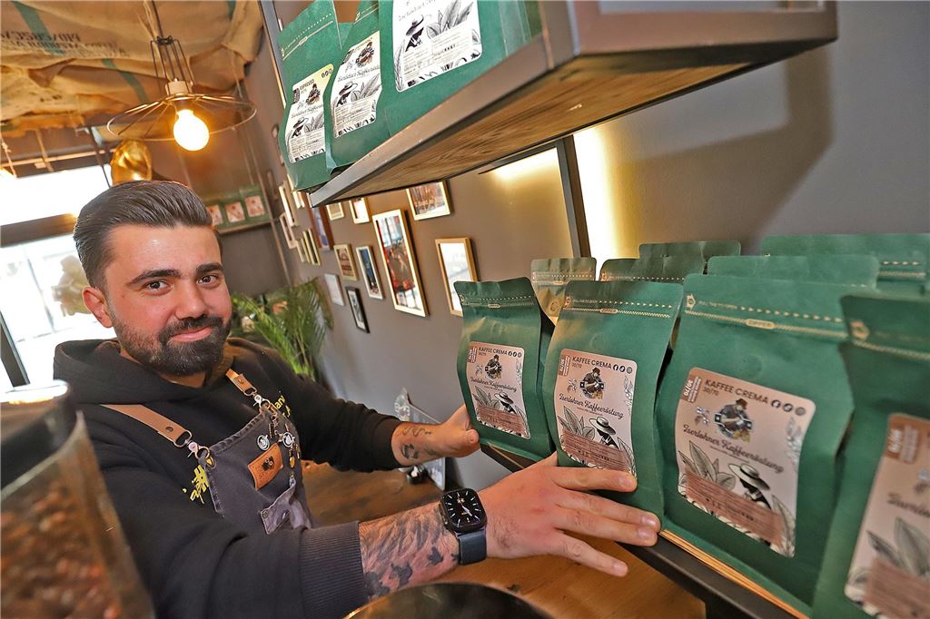 Neueröffnung: Café #01 bietet Kaffeespezialitäten in Toplage Inhaber Anas Khoja steht an einem Regal, in dem abgepackte Kaffeebohnen stehen.
