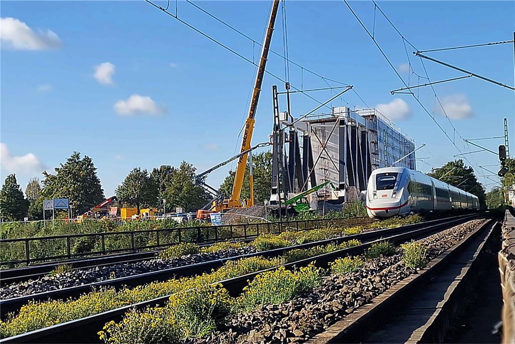Spektakulärer Brückenneubau: A1 muss gesperrt werden Die Deutsche Bahn erneuert die Eisenbahnbrücke über der A1 in Unna im Bereich Massener Kirchweg/Grenzstraße. Neben den Gleisen liegt bereits die neue Eisenbahnbrücke. Daneben fährt ein ICE.