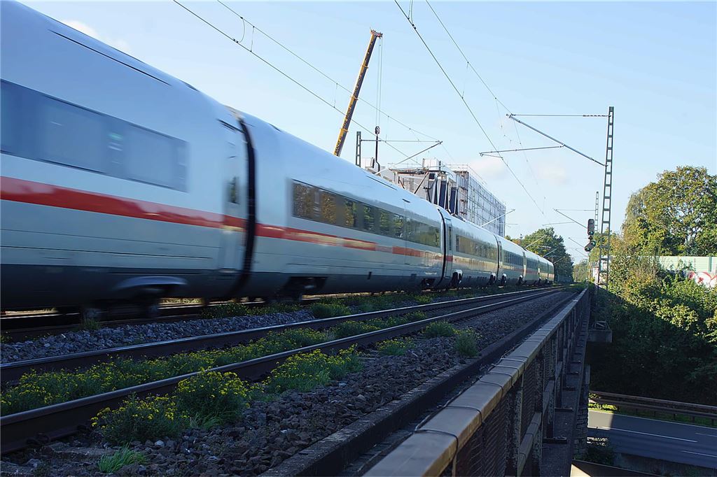 Die Deutsche Bahn erneuert die Eisenbahnbrücke über der A1 in Unna im Bereich Massener Kirchweg/Grenzstraße. Ein ICE fährt über die alte Eisenbahnbrücke.