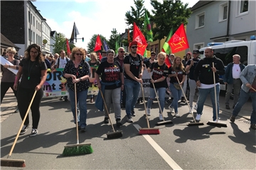 Die Gegendemonstranten starten ihre Aktion „Straßenkehrer“, nachdem die Rechten vorbeigezogen sind.