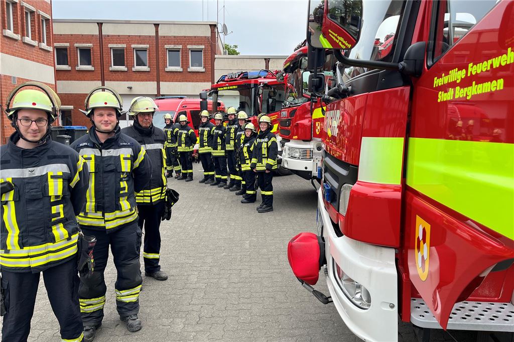 Unruhige Nacht für die Feuerwehr in Kamen und Bergkamen Feuerwehrleute der Einheit Mitte stehen vor ihren Fahrzeugen.